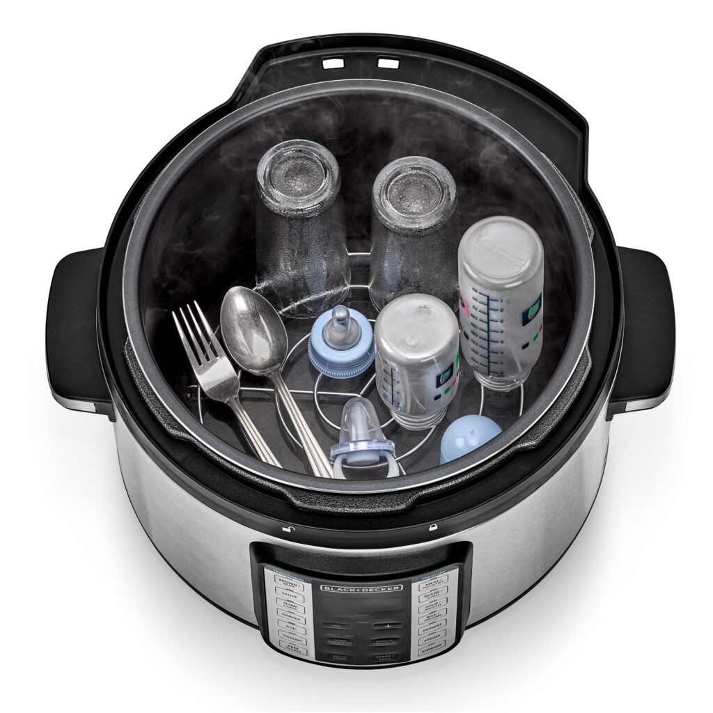Baby bottles, jars, and utensils being steamed inside the open Black+Decker PCP1010 pot