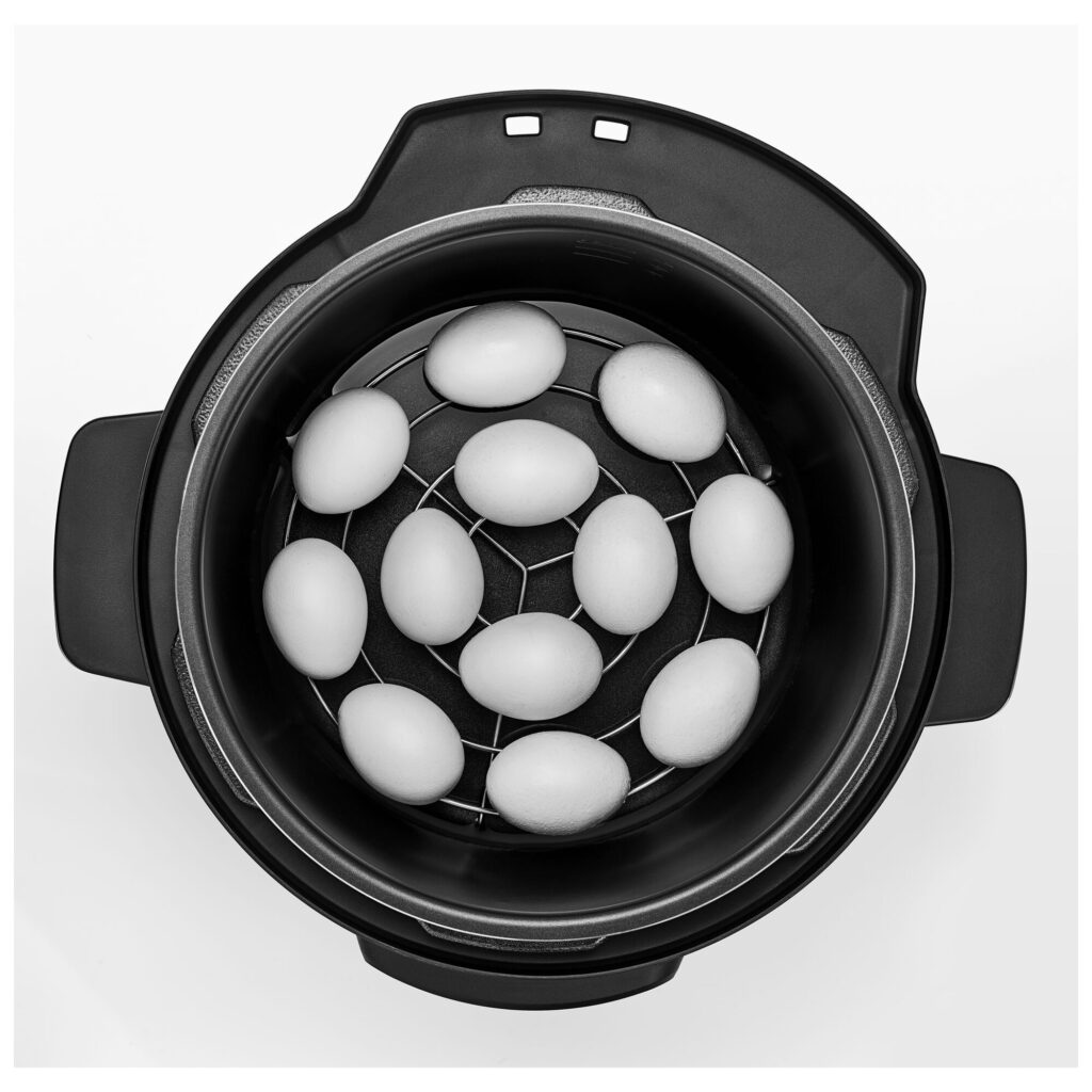 Eggs arranged on the steaming rack inside the Black+Decker PCP1010 pot, viewed from above