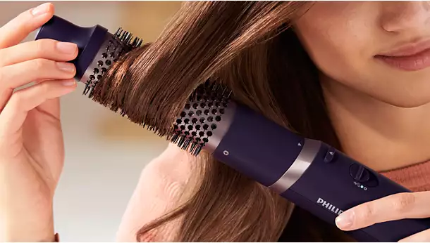 لقطة مقربة لتفاصيل الفرشاة الحرارية Philips BHA305 أثناء إنشاء تجعيدات ناعمة وإضافة حجم للشعر.