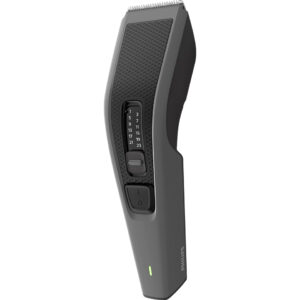 A three-quarter view of the grey Philips Hair Clipper HC3525 against a solid black background. The clipper features a textured grip, a central zoom wheel with length settings from 1 to 23, an on/off button, a silver stainless steel blade at the top, and a green battery indicator light near the Philips logo at the base.