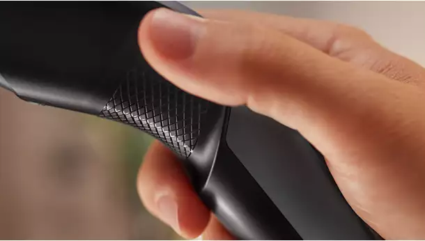 Close-up of a hand holding the ergonomic textured handle of a Philips Hair Clipper Series 3000 HC3525 for non-slip control.