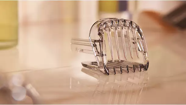 Close-up of the transparent adjustable hair trimming comb attachment for the Philips Hair Clipper Series 3000 HC3525 resting on a surface.